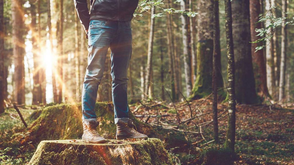 Persona de pie sobre un tronco con una actitud determinativa